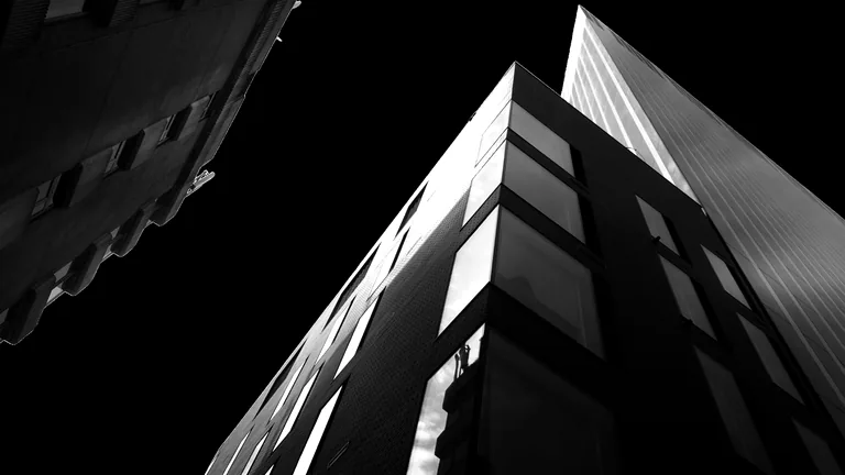 Modern apartment buildings photographed from below in high-contrast black and white